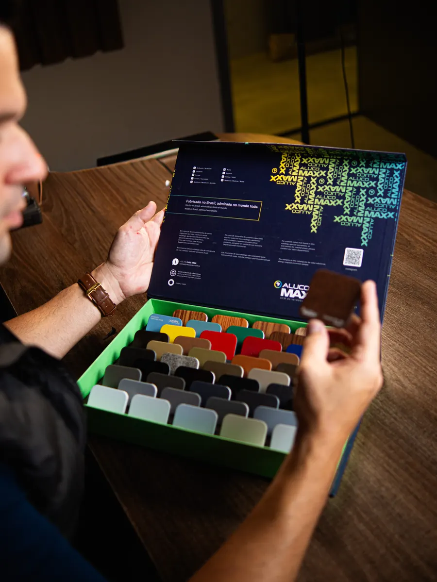 Thiago Bezerra analisando catálogo de cores ACM Arte Final Brasil